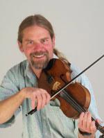 photo of Kevin McMullin playing fiddle and smiling