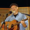 Tom Neilson performing with his guitar