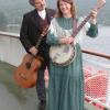 photo of Dave Para holding a guitar, and Cathy Barton holding a banjo