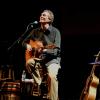 photo of Dennis Warner singing and playing guitar in concert